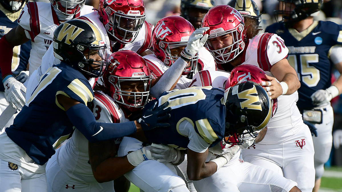 Virginia Union football players try to bring down a Wingate player in a D2 football playoff game on Nov. 23, 2024.