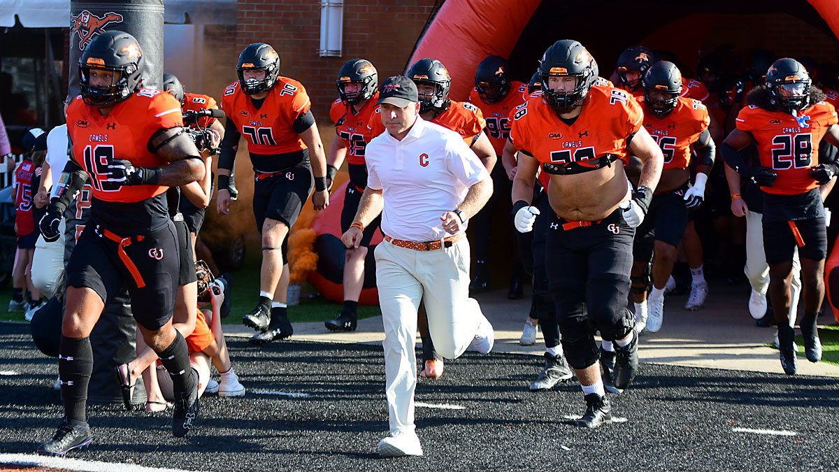 Campbell football players and coach Braxton Harris before a 2024 game against Stony Brook.