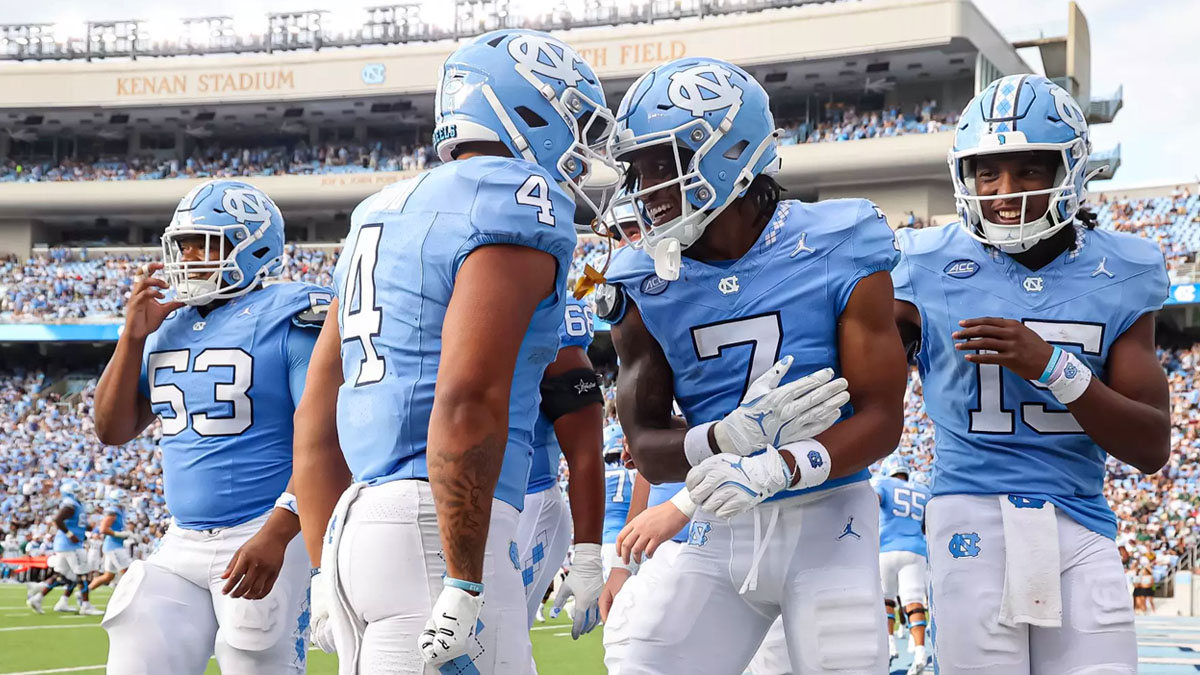 UNC football players celebrating during a 2024 game.