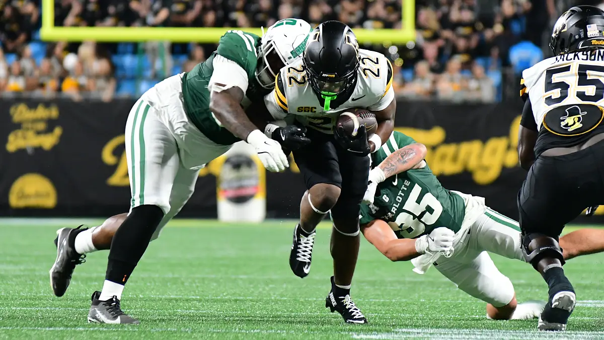 Appalachian State's Jaquari Lewis runs between Charlotte tacklers in the teams' season opener at Bank of America Stadium.