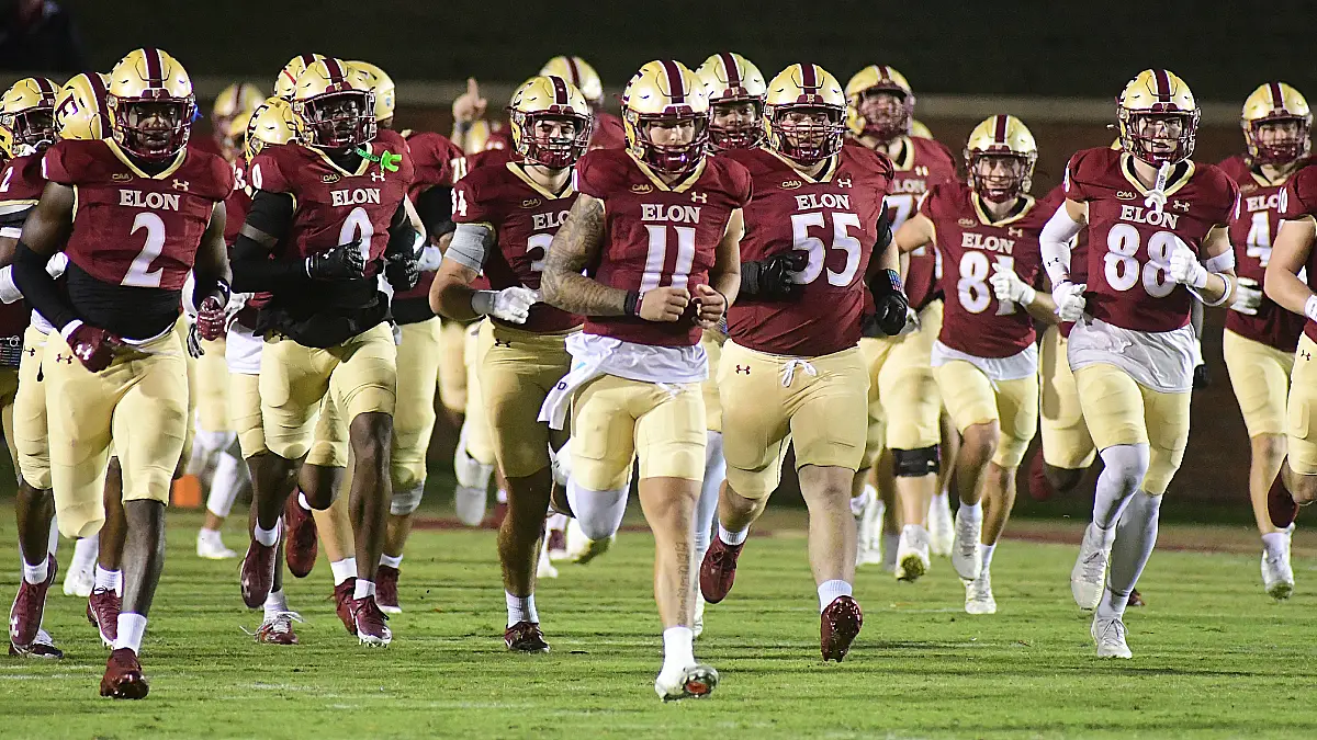 Quarterback Landen Clark and the Elon Phoenix football team take the field at the start of a game against Davidson.