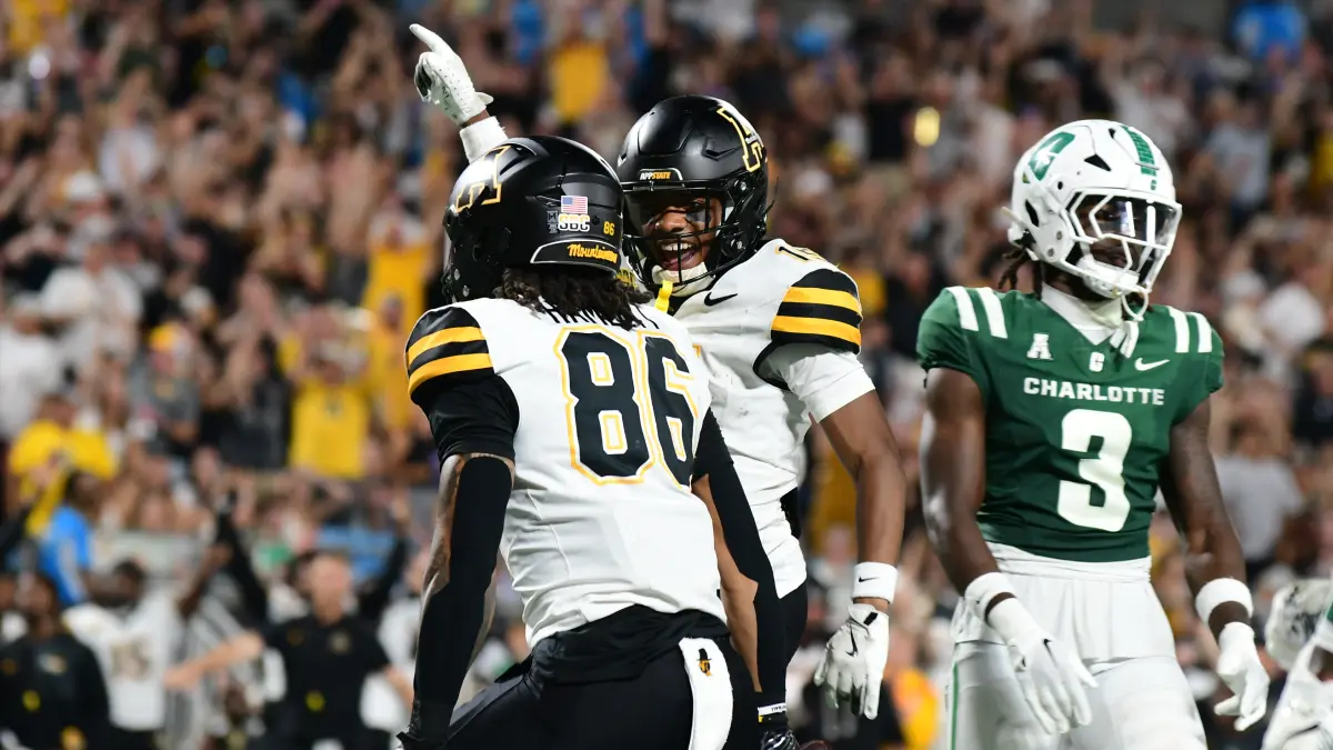 Appalachian State football players Kanen Hamlett and Thomas Davis celebrate a big defensive play in an August 2025 game against Charlotte