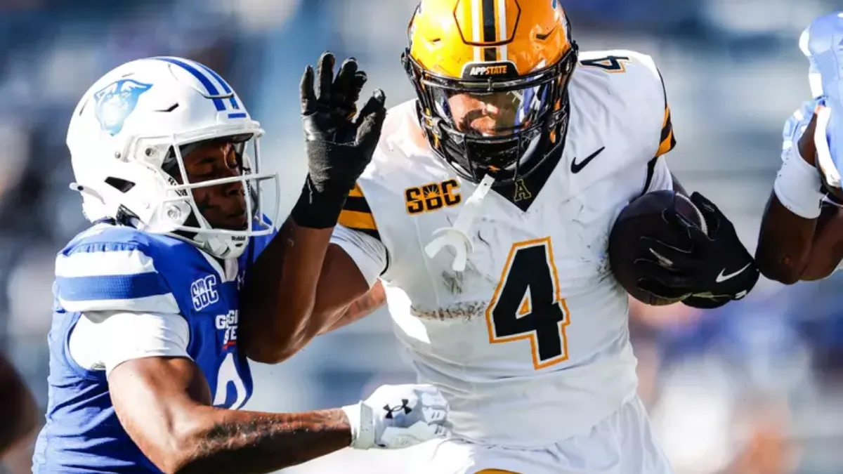 Izayah Cummings of Appalachian State stiff-arms a Georgia State defender during the Mountaineers’ win in Atlanta.