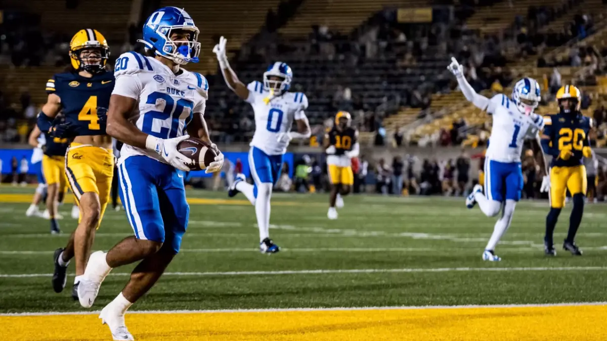 Duke running back Nate Sheppard scores against Cal while teammates behind him celebrate.