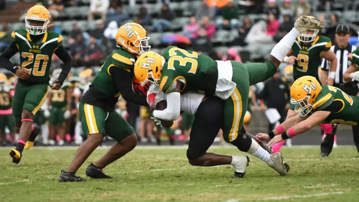 Methodist University football players make a tackle in a 2025 game.