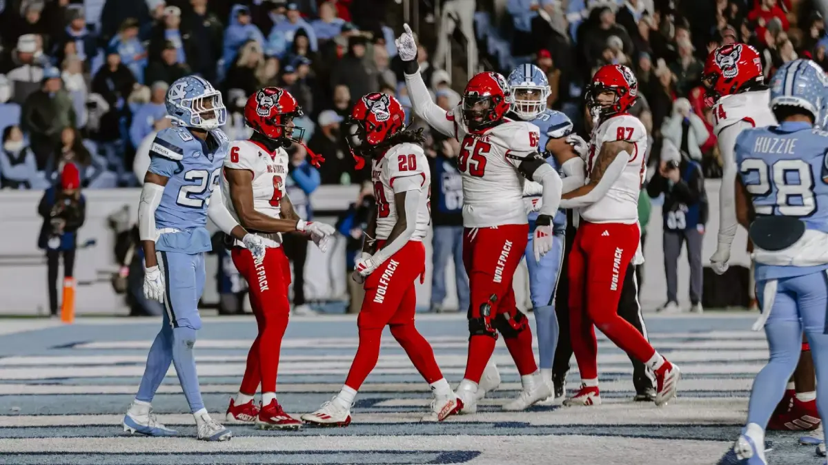 NC State football players celebrate in the UNC end zone during the teams' meeting in Chapel Hill in 2024