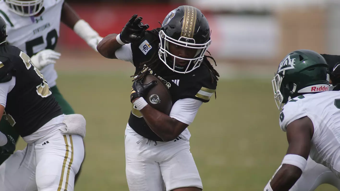 UNC Pembroke football player splits between tacklers during a 2025 game.