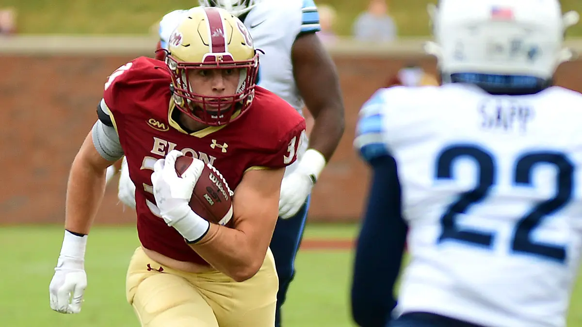 Elon's Dylan Magazu rumbles upfield after making a catch while a Villanova player defends.