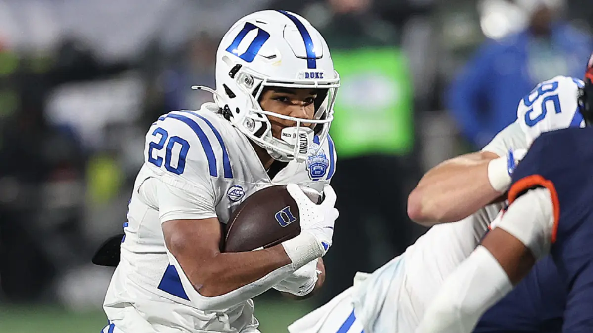 Duke running back Nate Sheppard holds the ball high and tight against VIrginia in the 2025 ACC title game.