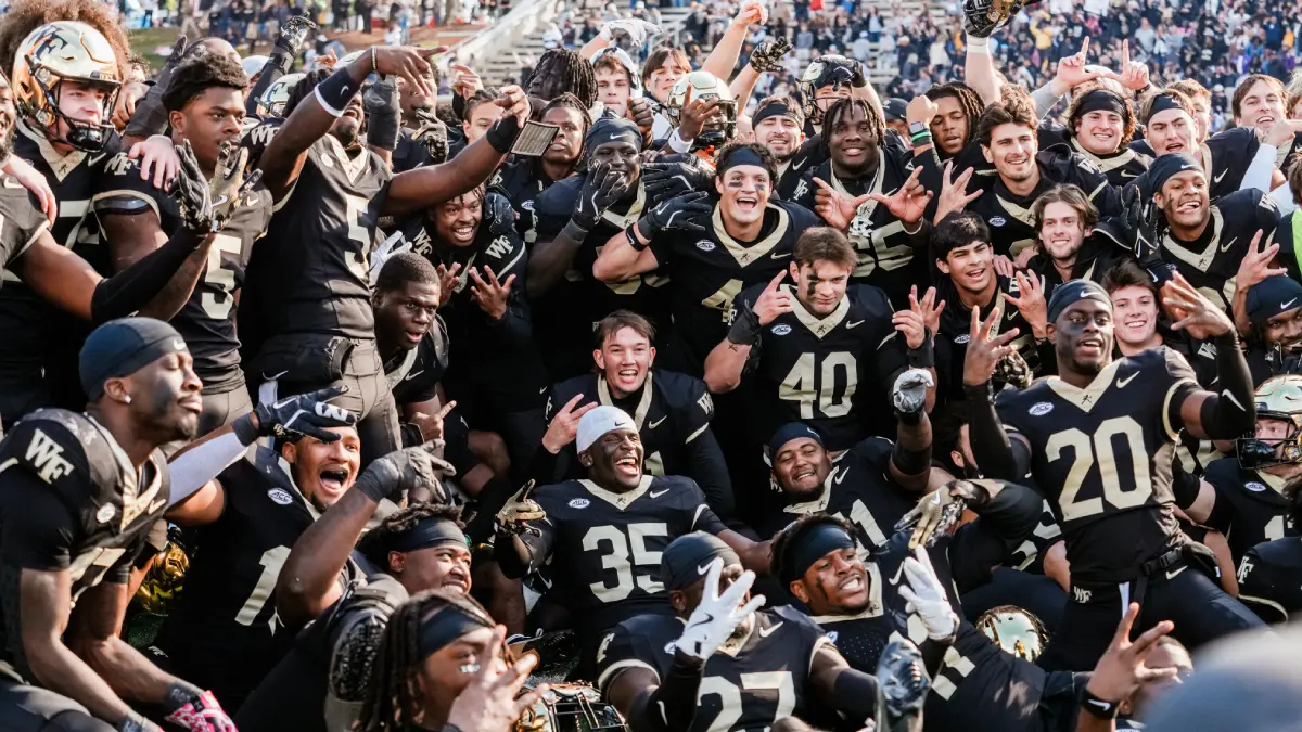 Wake Forest football players pose for a group photo on the field at Allegacy Stadium after an upset win over SMU