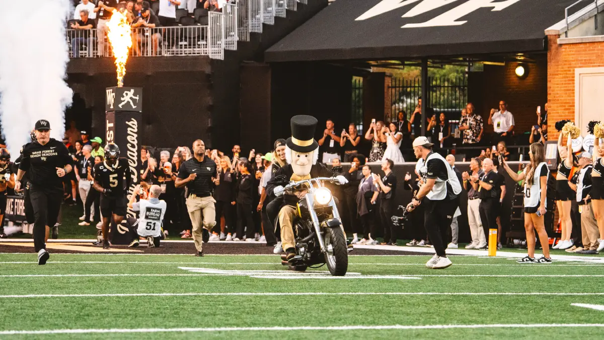 The Wake Forest Demon Deacon mascot rides onto the field on a motorcycle before the start of a Demon Deacons home game.